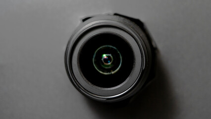 black camera in black hole, concept, lens that looks out through a torn hole in black paper. camera...