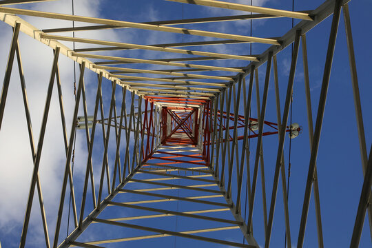 high pylon with high voltage cables for the transport of electricity and clouds on the sky