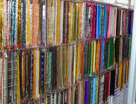 shelves of many necklaces of colorful crystal glass stones in the neogizo of the shopping center without people