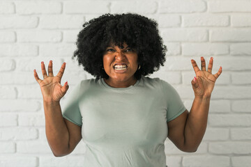 Angry african american woman screaming on brick background. Bad aggressive emotions and...