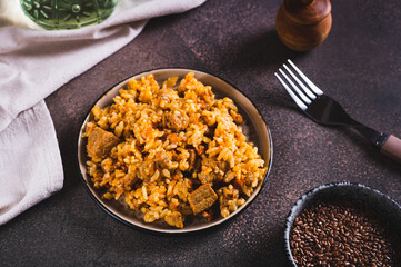 Traditional spicy pilaf with rice and meat on a plate on the table
