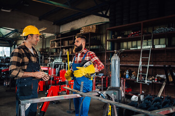 Two coworkers talking about the project while wearing safety gear.