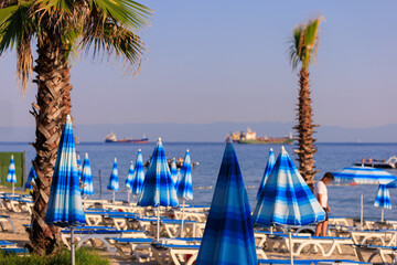 View of the beach and sea with umbrellas and sun loungers, summer sunny day