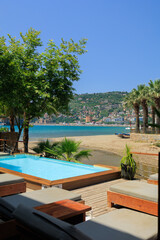 View of the beach and sea with umbrellas and sun loungers, summer sunny day