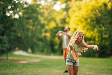 A girl is holding racquet and playing badminton in nature.