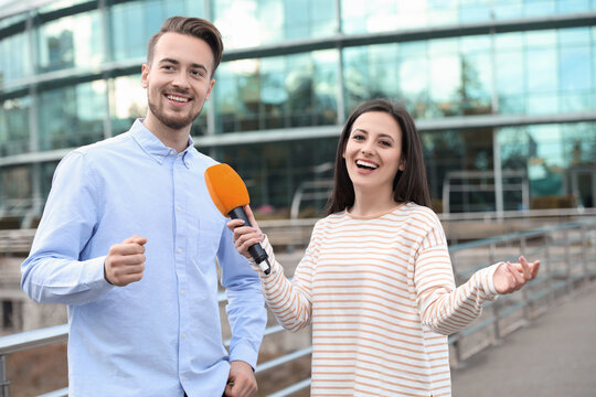 Young journalist interviewing man on city street
