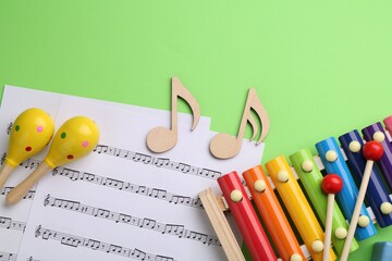 Tools for creating baby songs. Flat lay composition with maracas and xylophone on green background