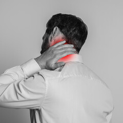 Man suffering from rheumatism on light background. Black and white effect with red accent in...