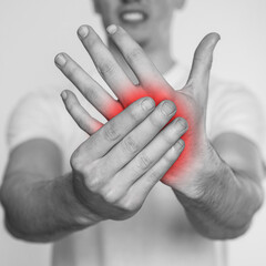 Man suffering from rheumatism on light background, closeup. Black and white effect with red accent...