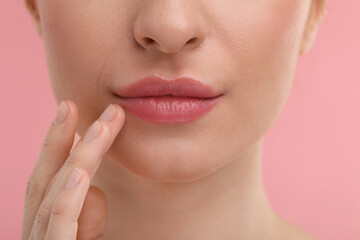 Obraz premium Young woman with beautiful full lips on pink background, closeup