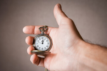 a pocket watch in the hands of a man