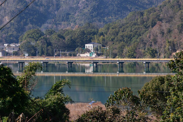 Fototapeta premium Un pueblo rural dentro de un bosque de montaña con un hermoso embalse y un puente muy largo.Muy bonito.