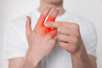 Man suffering from rheumatism on light background, closeup