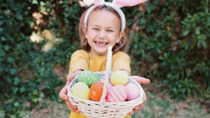 Easter egg hunt. Excited emotion surprise adorable child girl in bunny ears rabbit costume hold basket with Easter colored eggs. Children positive emotions. Kid happy Easter. Egg hunting outside