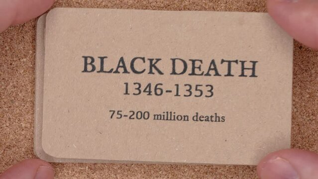 Macro top down shot stack of craft paper cards with world epidemics and pandemics list number of deaths from diseases written on them, historical timeline