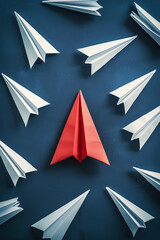 Emerging leader concept. White paper origami airplanes led by red airplane. navy blue background. High quality photo