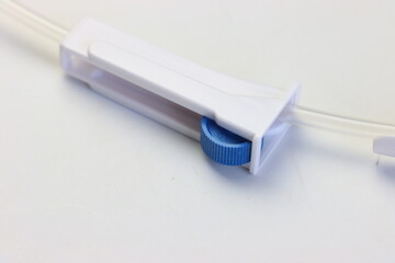 Infusion set roller clamp close up in a white background 
