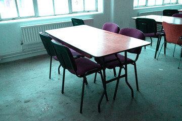 An Empty Desolate Classroom With Empty Desk and Seats