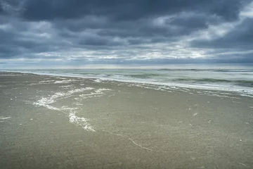 Schilderijen op glas Dark clouds over sandy beach on the North Sea coast of the Netherlands © fotografiecor