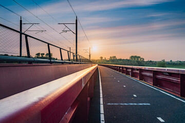 Red railroad bridge named 'Hanzeboog' over the IJssel river in the dutch Delta - obrazy, fototapety, plakaty