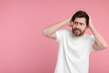 Fototapeta na wymiar Portrait of surprised man on pink background, space for text
