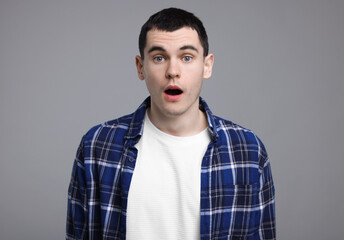 Portrait of surprised man on grey background