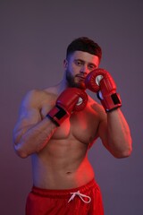 Man in boxing gloves on color background