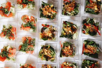 Beautifully decorated catering banquet table with different food snacks and appetizers with sandwich, caviar, fresh fruits on corporate christmas birthday party event or wedding celebration.