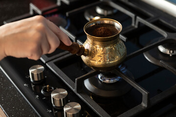 Close up shot of preparation of turkish coffee using copper cezve on the gas stove