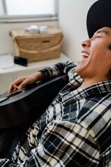 Latin man playing acoustic guitar at home