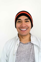 Latin man wearing a beanie on the white background smiling