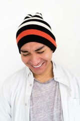 Latin man wearing a beanie on the white background smiling