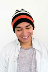 Latin man wearing a beanie on the white background smiling