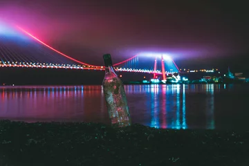 Foto op Canvas artistic bottle and a colorful bridge at night © Izmir