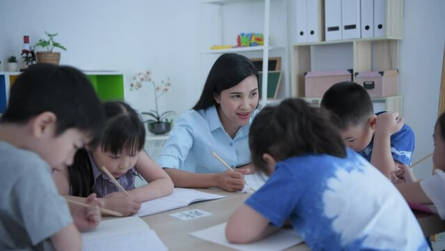 (Chinese wording translation:insect, introduction) Educational concept of 4k Resolution. The teacher is teaching children to learn Chinese in the classroom.
