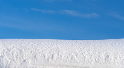 winter landscape, snow-covered field with snowdrifts against the blue sky