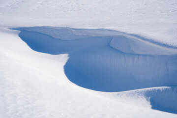 Fototapeta na wymiar winter landscape, snow-covered field with snowdrifts against the blue sky