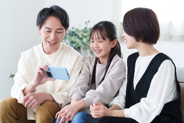 Obraz premium スマートフォンで動画を見る家族