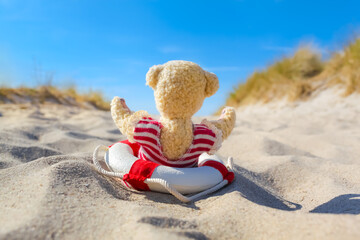 Seaside Dune Summer Pleasure / Little teddy bear with swimsuit and nostalgic life buoy have fun at beach sand (copy space) - 750218983