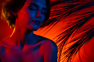 Photo of shiny adorable woman naked shoulders enjoying tropical resort sunset isolated red neon color background