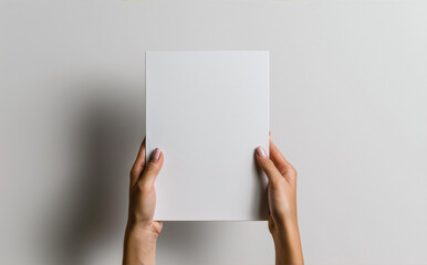 Two hands holding a blank white square against a white background