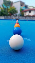 Fototapeta na wymiar Colorful pool balls in a line on a blue table