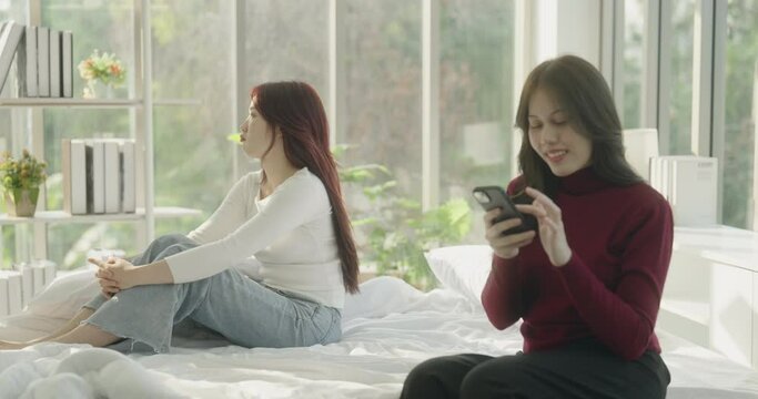 Roommate concept of 4k Resolution. Asian woman is upset because girlfriend is not interested in the house. She is addicted to the game and has no interest in her surroundings.