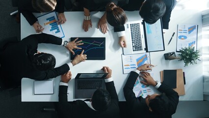 Top view of smart business people brainstorm marketing idea at meeting table while compare stock market investment data between laptop and tablet. Business team planning financial plan. Directorate.