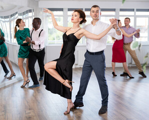 During rehearsal of reporting concert, man and woman participants of dance workshop perform figure...
