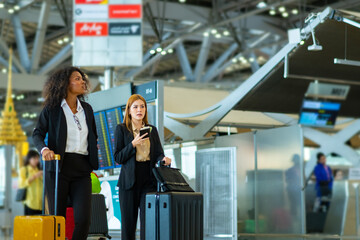 Confidence Businesswoman partnership dragging suitcase walking to airline check in counter in...