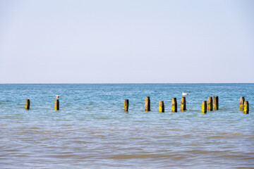 View of the North Sea in Norfolk, England, with wooden groynes half submerged, can be used as a background