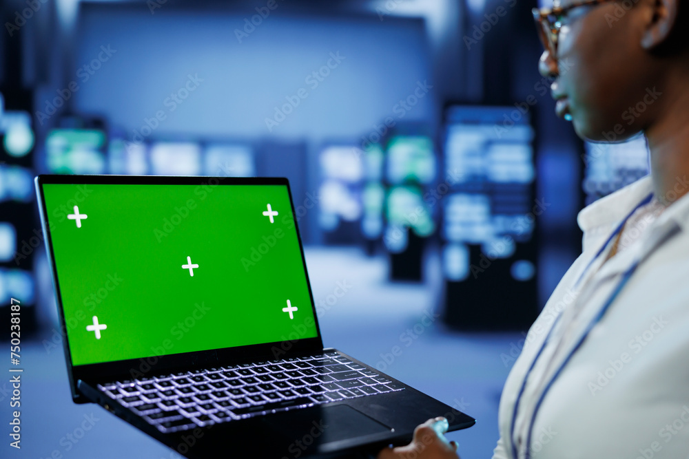 Poster programmer in server room uses green screen laptop to future proof network from downtimes and unexpe