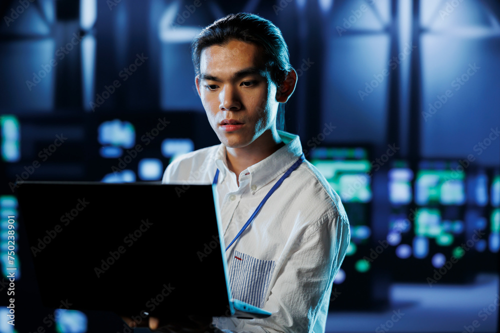 Poster qualified engineer between server hub rows providing processing resources for businesses worldwide. 
