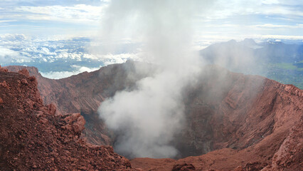 Smoke from inside the crater of an active volcano in Mount Kerinci with large caldera in Indonesia